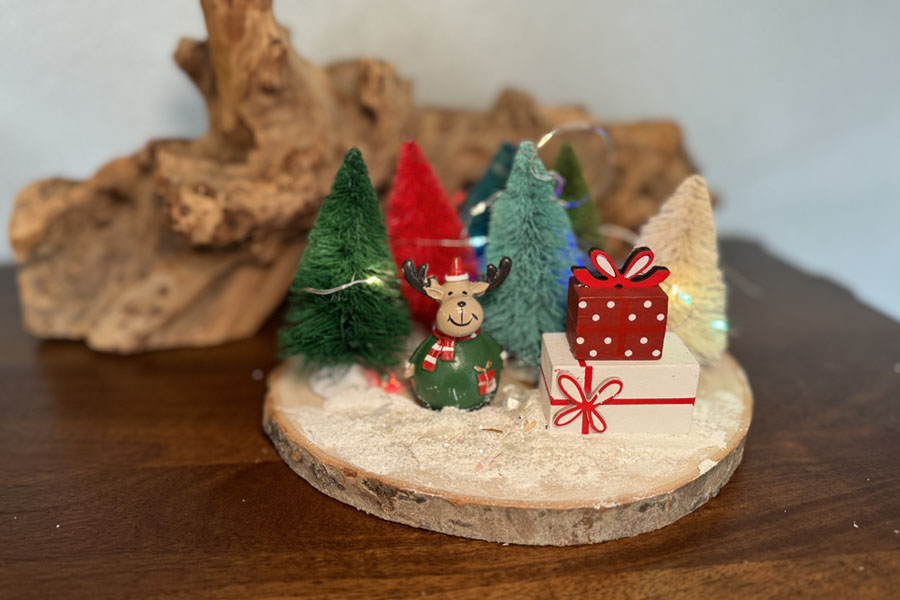 Mini Christmas trees on a wood slice.