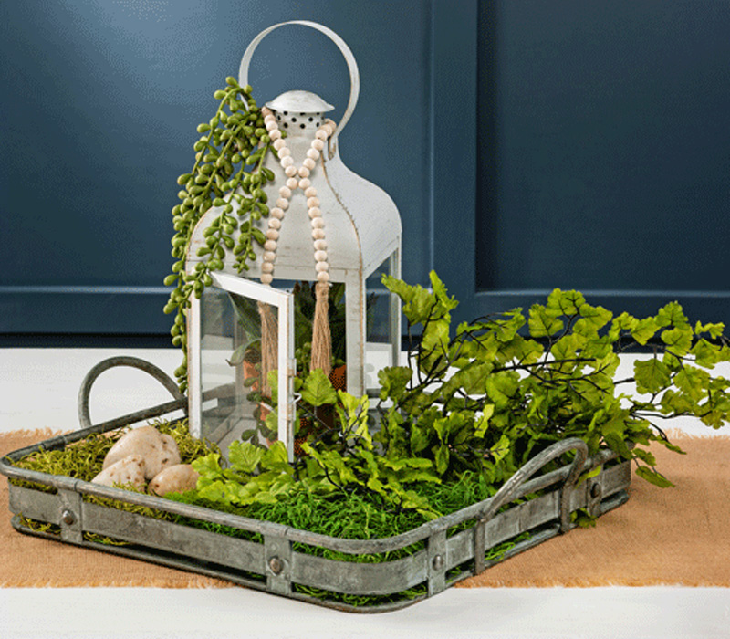 white lantern on tray with fern